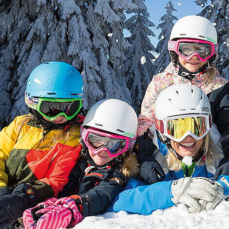 Kinder beim Skiunterricht in einer Minigruppe